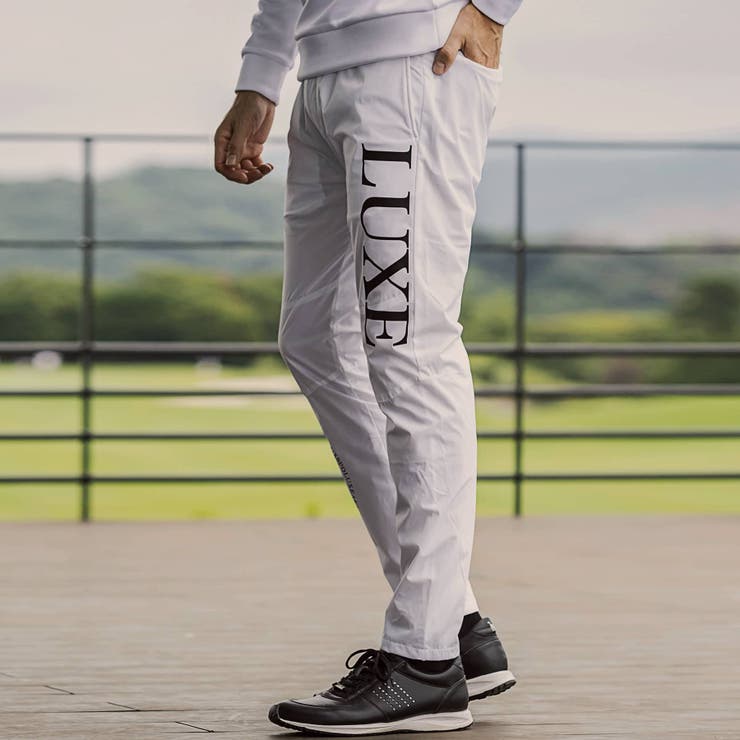 LUXEAKMPLUS リュクスエイケイエムプラス サークルロゴウィンドパンツ